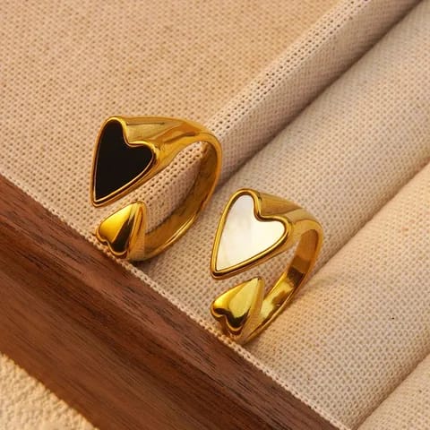 Gold heart-shaped rings on a beige fabric background