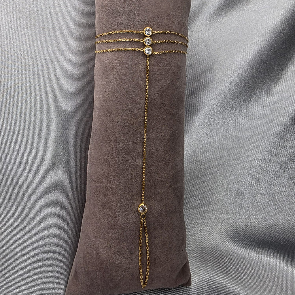 Gold bracelet with gemstones on a brown fabric background