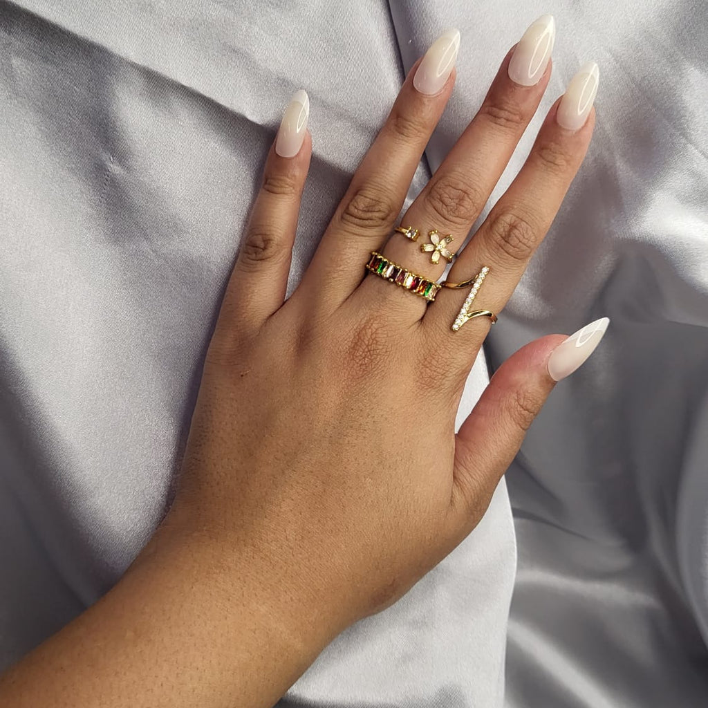 Hand with multiple rings on a neutral background