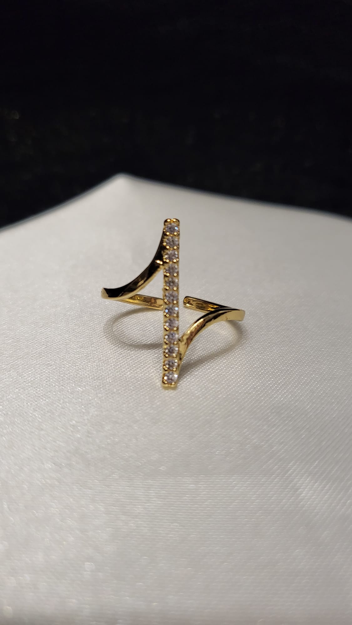 Gold ring with a unique design on a white surface
