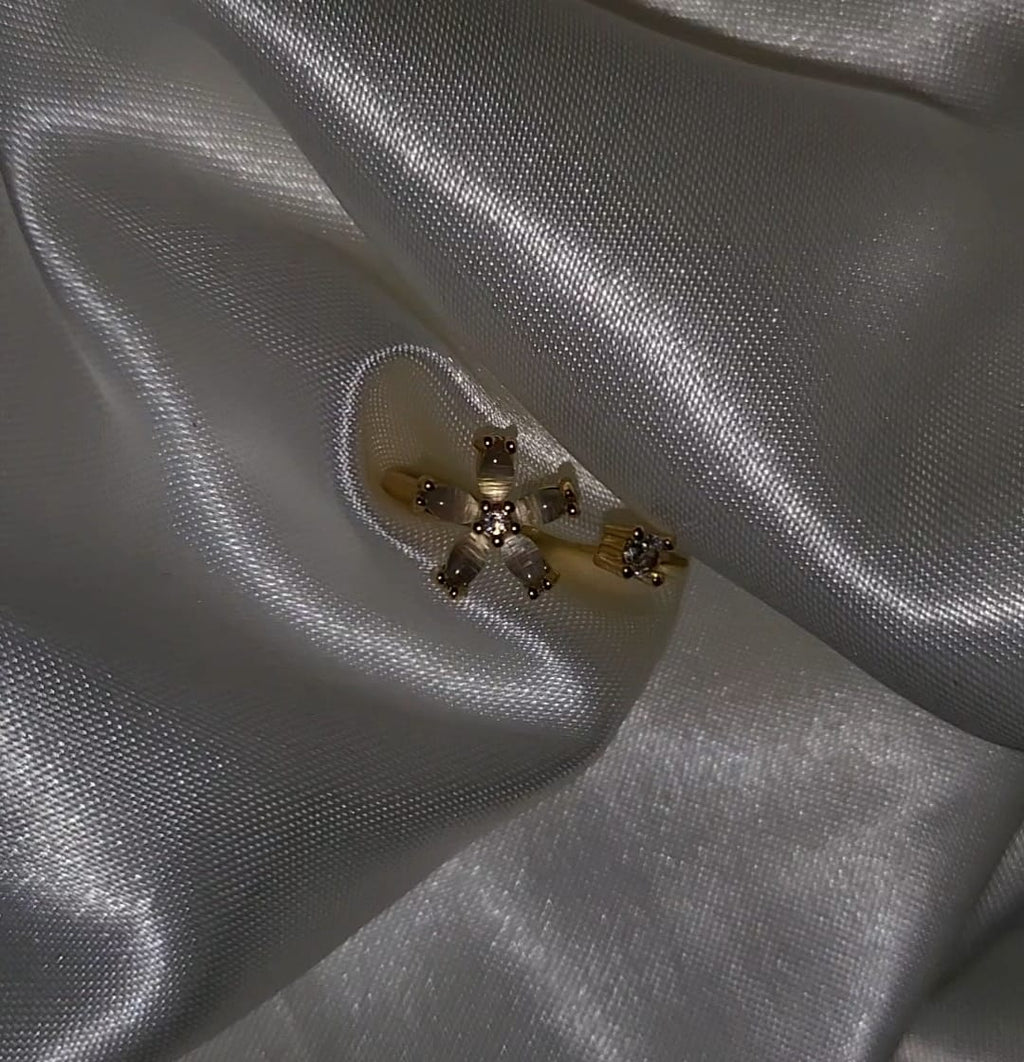 Gold brooch with gemstones on a white fabric background