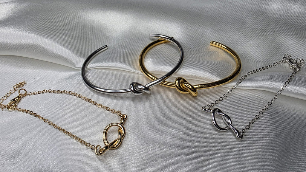 Set of gold and silver jewelry on a satin surface